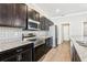 Stylish kitchen featuring stainless steel appliances, dark cabinets, and granite countertops at 411 Lily Ln, Davenport, FL 33837