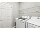 The laundry room has a washer and dryer and a wire rack shelf at 411 Lily Ln, Davenport, FL 33837