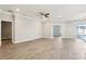 Spacious living room with wood floors, ceiling fan, and neutral paint, bathed in natural light at 411 Lily Ln, Davenport, FL 33837