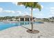 Inviting community pool area with a covered pavilion, surrounded by palm trees and ample seating for residents at 411 Lily Ln, Davenport, FL 33837