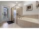 Bright bathroom featuring a glass shower, soaking tub, and backyard views at 4149 Lana Ave, Davenport, FL 33897