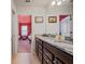 Bathroom features a dual-sink vanity with granite countertops, next to a bedroom in this well-designed space at 4149 Lana Ave, Davenport, FL 33897