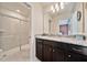 Bright bathroom features a granite countertop vanity and walk-in shower with sliding glass door at 4149 Lana Ave, Davenport, FL 33897