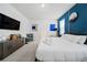 Modern bedroom featuring sleek furniture, a flat-screen TV, and stylish blue accent wall at 4149 Lana Ave, Davenport, FL 33897