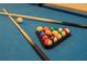 Close-up of billiard balls racked on a blue felt pool table, complemented by cues, suggesting leisure and entertainment at 4149 Lana Ave, Davenport, FL 33897