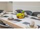 Dining room table setting with eight chairs, plates, and a basket of fruit in the center at 4149 Lana Ave, Davenport, FL 33897