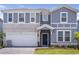 Charming two-story home with a two-car garage, stone accents, and a beautifully landscaped front yard at 4149 Lana Ave, Davenport, FL 33897