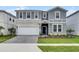 Charming two-story home showcasing a stone facade, landscaped front yard, and covered entrance at 4149 Lana Ave, Davenport, FL 33897