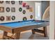 Stylish game room featuring a blue felt pool table and eclectic wall decor with vintage records and art prints at 4149 Lana Ave, Davenport, FL 33897