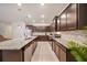 Modern kitchen with granite countertops, stainless steel appliances, and dark wood cabinets with breakfast bar at 4149 Lana Ave, Davenport, FL 33897