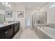 Relaxing bathroom featuring a soaking tub, a separate glass-enclosed shower, and a double vanity with granite top at 4149 Lana Ave, Davenport, FL 33897