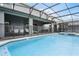 Covered outdoor patio with stylish seating overlooking a screened pool and spa area at 4149 Lana Ave, Davenport, FL 33897