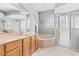 Bright main bathroom with double sinks, tub, separate shower, and glass block window at 4263 Lillian Hall Ln, Orlando, FL 32812