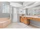 Bright bathroom with double sinks, tub, separate glass shower, and neutral tile flooring at 4263 Lillian Hall Ln, Orlando, FL 32812