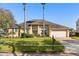 Inviting home exterior with a lush lawn, a brick driveway, mature trees, and well-maintained landscaping at 4263 Lillian Hall Ln, Orlando, FL 32812