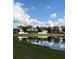 Calm waters of a pond reflect the clear blue sky and surrounding lush greenery at 4263 Lillian Hall Ln, Orlando, FL 32812