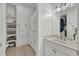 Bright bathroom with a floral shower curtain, open shelving, and a vanity with a marble countertop at 4533 Burke St, Orlando, FL 32814