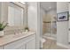 Bathroom featuring a glass enclosed shower, marble countertops and backsplash, and a decorative mirror at 4533 Burke St, Orlando, FL 32814