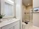 Bright bathroom with a vanity, framed mirror, white cabinets, tile floors, and a tiled walk-in shower at 4533 Burke St, Orlando, FL 32814