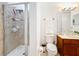 Bathroom with a glass enclosed shower, updated vanity, toilet, fixtures, and accessories at 4533 Burke St, Orlando, FL 32814