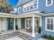 An inviting covered patio with classic columns offers a cozy outdoor seating area and charming architectural details at 4533 Burke St, Orlando, FL 32814