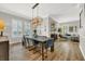 Open dining room and living room featuring a chandelier, hardwood floors, and large windows at 4533 Burke St, Orlando, FL 32814