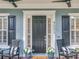 Close-up of a charming front door with black shutters and relaxing seating area at 4533 Burke St, Orlando, FL 32814