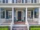 Inviting front porch with brick flooring, comfortable seating, and elegant column details at 4533 Burke St, Orlando, FL 32814