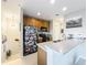 Kitchen with wood cabinets, a breakfast bar, stainless steel appliances and a refrigerator adorned with stickers at 4533 Burke St, Orlando, FL 32814