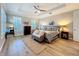 Beautiful main bedroom features a tray ceiling, wood floors, neutral colors, and plantation shutters at 4533 Burke St, Orlando, FL 32814