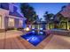 Inviting backyard pool with a fire pit, lush tropical landscaping, and a spa at twilight at 4533 Burke St, Orlando, FL 32814