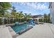 Beautiful pool area surrounded by palm trees, manicured hedges, and a cozy fire pit at 4533 Burke St, Orlando, FL 32814