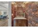 Chic powder room with bold wallpaper, marble countertop, and elegant lighting fixtures at 4533 Burke St, Orlando, FL 32814