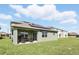 Exterior view of a home with solar panels, a covered patio, and a green lawn at 5226 Mahogany Dr, Mount Dora, FL 32757