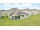 Lush backyard featuring solar panels and covered patio seating, ideal for outdoor relaxation and sustainable living at 5226 Mahogany Dr, Mount Dora, FL 32757