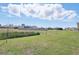 Lush backyard with expansive green space, a tranquil pond, and a view of neighboring homes at 5226 Mahogany Dr, Mount Dora, FL 32757