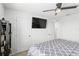 A tidy, carpeted bedroom features a ceiling fan and an entertainment area with mounted television at 5226 Mahogany Dr, Mount Dora, FL 32757