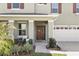 Charming home's front door and walkway, framed by lush landscaping and a two-car garage at 5226 Mahogany Dr, Mount Dora, FL 32757