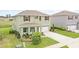 Beautifully landscaped two-story home with a two car garage, lush green lawn, and a welcoming front porch at 5226 Mahogany Dr, Mount Dora, FL 32757