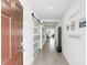 Bright hallway featuring neutral paint, tile flooring, and a modern barn door at 5226 Mahogany Dr, Mount Dora, FL 32757