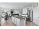 A kitchen with white cabinets, stainless steel appliances, large granite island, and seating at 5226 Mahogany Dr, Mount Dora, FL 32757