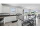 Bright kitchen featuring white cabinetry, stainless steel appliances, a granite island, and a tiled floor at 5226 Mahogany Dr, Mount Dora, FL 32757