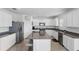 Bright kitchen features white cabinets, granite countertops, stainless steel appliances, and an island at 5226 Mahogany Dr, Mount Dora, FL 32757