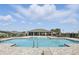 Stunning community pool with a covered seating area, lounge chairs, and clear blue water at 5226 Mahogany Dr, Mount Dora, FL 32757