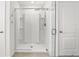 Walk-in shower with glass enclosure features white tiling and door, offering a clean, modern design at 5226 Mahogany Dr, Mount Dora, FL 32757