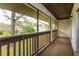 Enclosed balcony with wooden railings and outdoor views of trees and green grass at 600 Northern Way # 404, Winter Springs, FL 32708