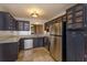 Modern kitchen with stainless steel appliances, stone countertops, and custom dark cabinetry at 600 Northern Way # 404, Winter Springs, FL 32708