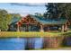 Outdoor pavilion with a wood frame, green roof, and pond view at 600 Northern Way # 404, Winter Springs, FL 32708