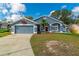 Charming one-story home with blue exterior, attached garage, landscaped yard, and a basketball hoop at 6018 Long Peak Dr, Orlando, FL 32810