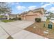 Spacious home featuring a three-car garage and lush landscaping at 6942 Remington View Ct, Orlando, FL 32829